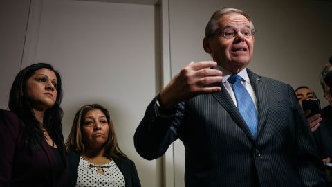 Sandra Diaz, left, and Victorina Morales stand by as Sen. Bob Menendez delivers remarks to reporters.