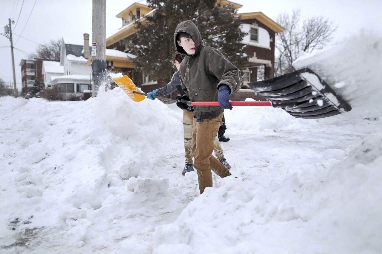 Nathan Tearman, front, and his brother James shovel the driveway of their home in Janesville, Wisconsin, on January 28.