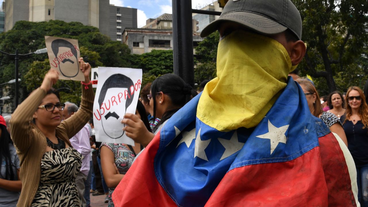 An opposition demonstrator covers his face with a Venezuelan national flag, during a protest against President Nicolas Maduro on January 30, 2019. 