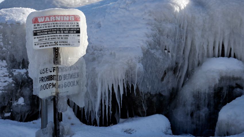 A warning sign is covered by ice at Clark Square park in Evanston, Ill., Wednesday, Jan. 30, 2019. A deadly arctic deep freeze enveloped the Midwest with record-breaking temperatures on Wednesday, triggering widespread closures of schools and businesses, and prompting the U.S. Postal Service to take the rare step of suspending mail delivery to a wide swath of the region. (AP Photo/Nam Y. Huh)