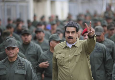 In this handout photo released by the Miraflores Presidential Press Office, Maduro flashes a "V for victory" hand gesture after arriving at the Fort Tiuna military base in Caracas on January 30.