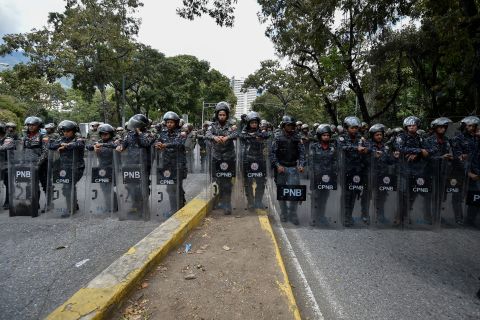 Members of the National Police line up to guard the entrance of Venezuela's Central University in Caracas during an anti-government protest on January 30.