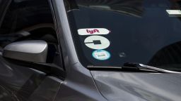 Lyft and Uber logos are seen on the windshield of a vehicle in New York.