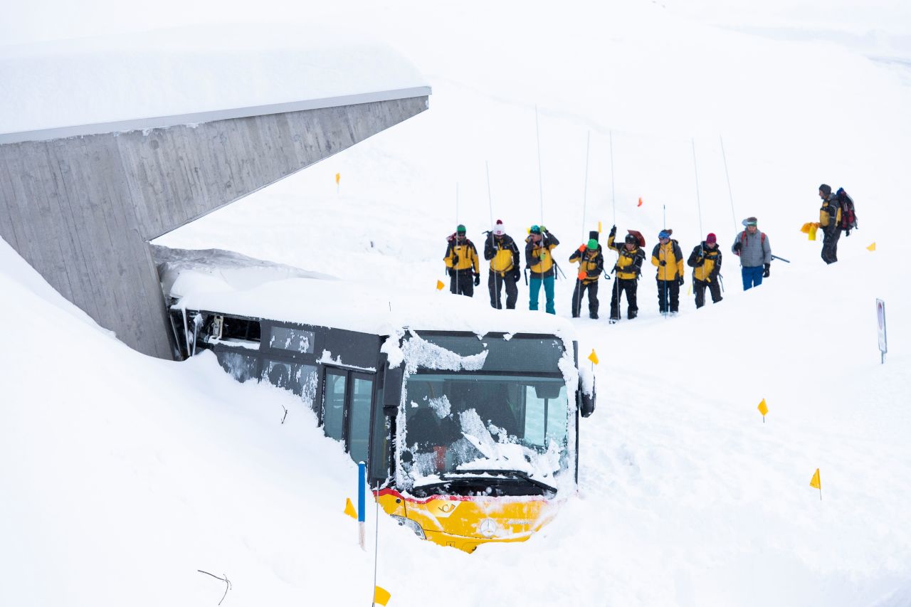 Search-and-rescue workers dig out a bus that had been caught by an avalanche in Hundwil, Switzerland, on Friday, January 11.