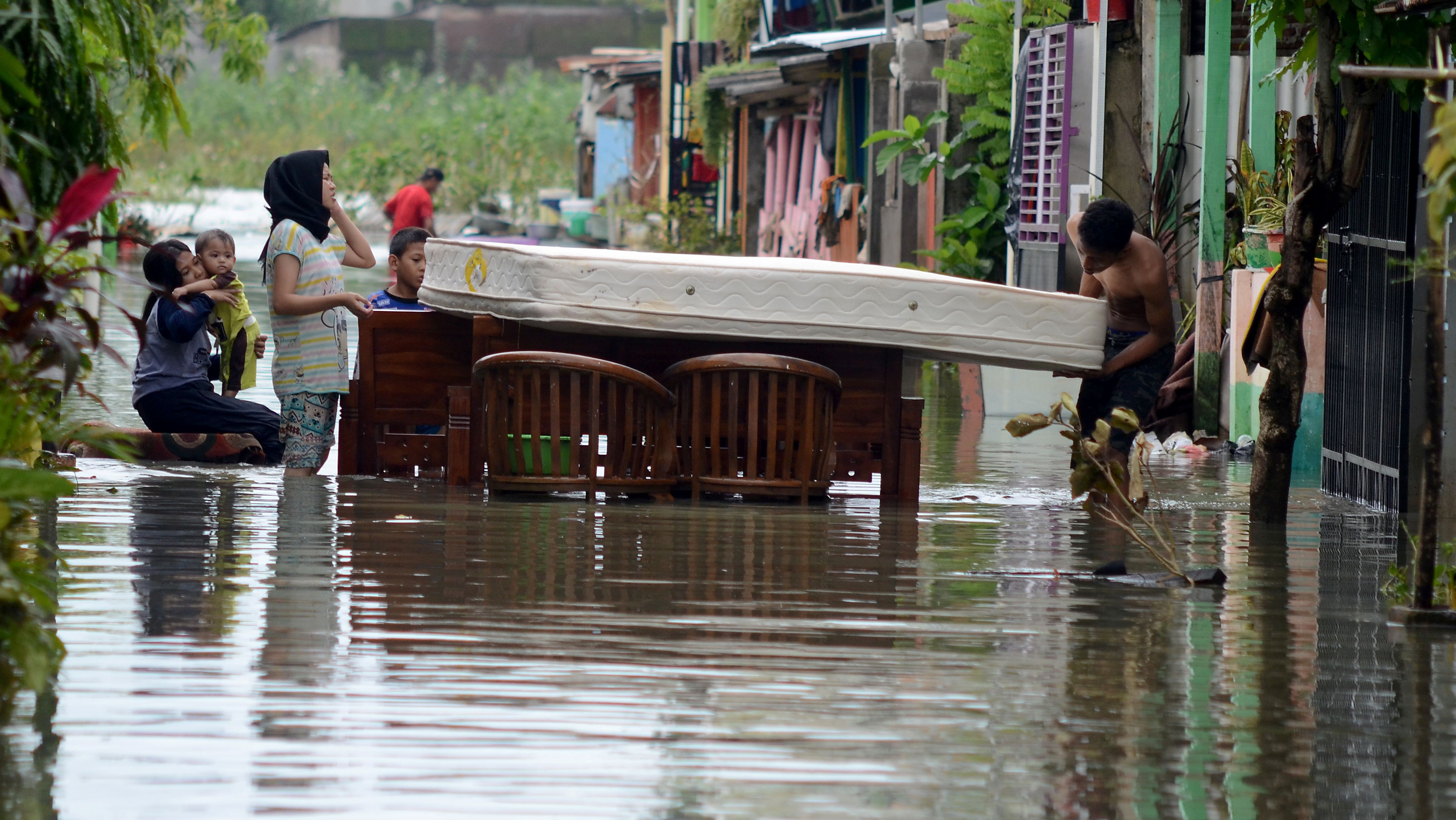 Residents clean up following floods in Makassar, Indonesia, on Friday, January 25.