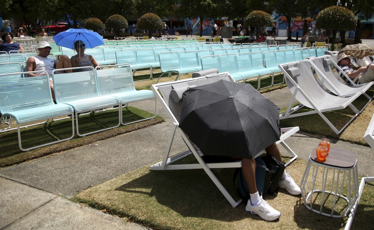 This tennis fan blocked the sun with an umbrella while watching the Australian Open from Garden Square on Friday, January 25.