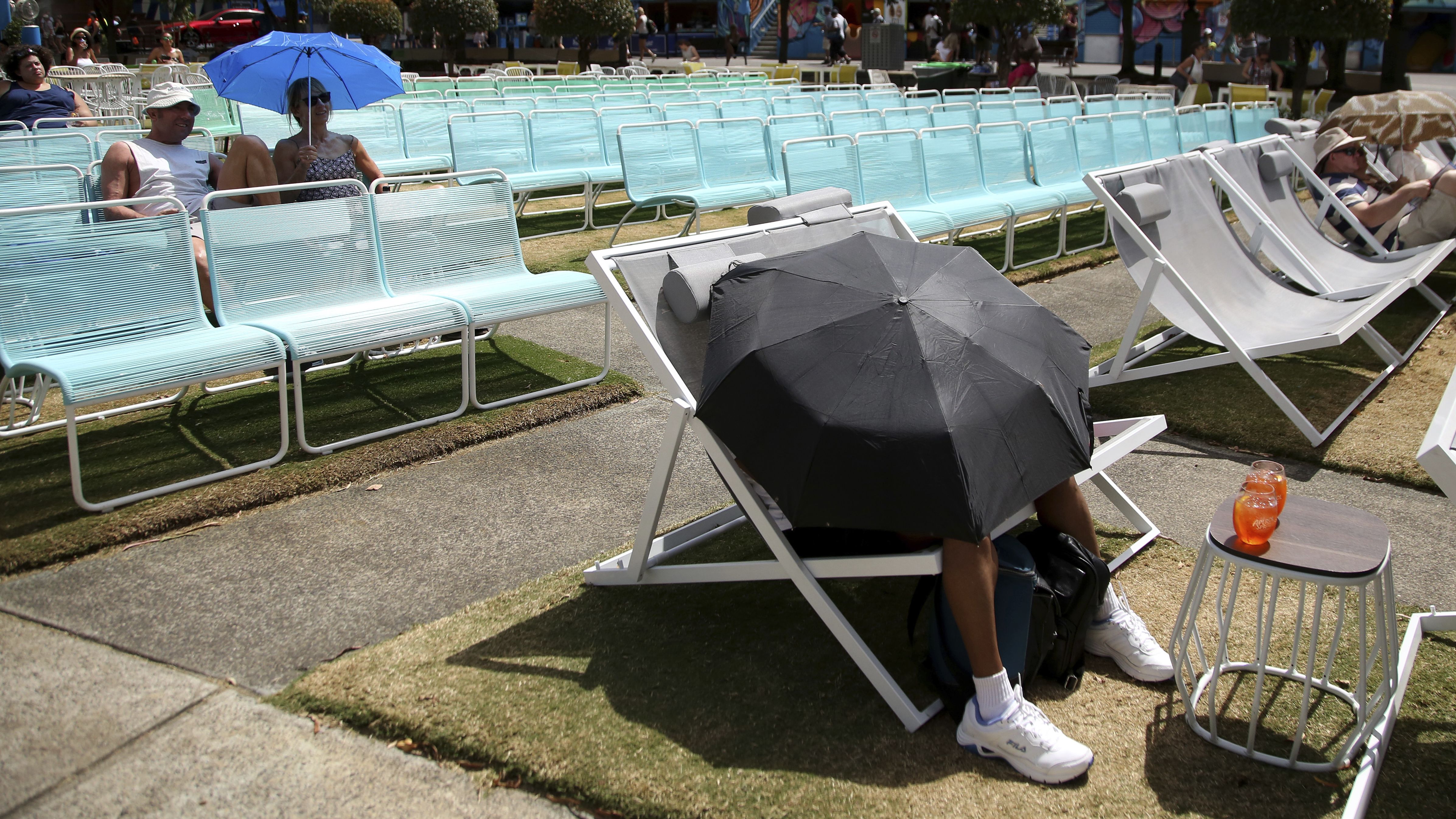 This tennis fan blocked the sun with an umbrella while watching the Australian Open from Garden Square on Friday, January 25.