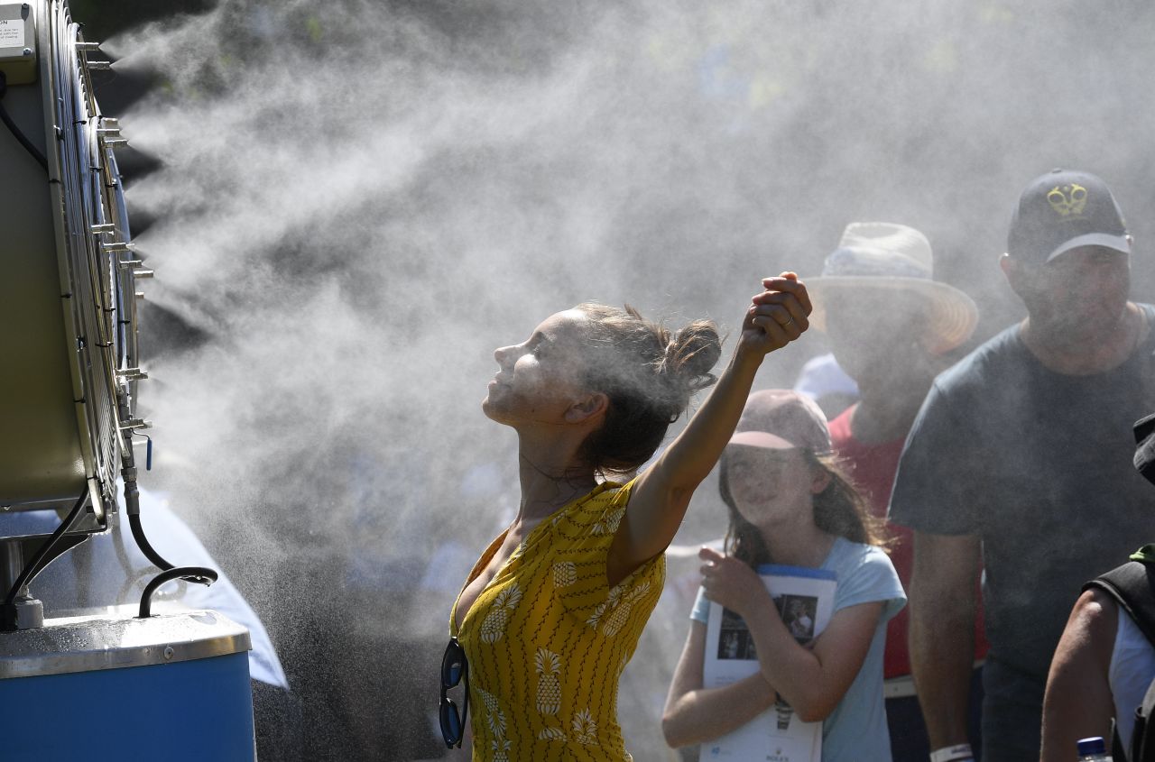 A tennis fan cools herself down while attending the Australian Open in Melbourne on Monday, January 14.