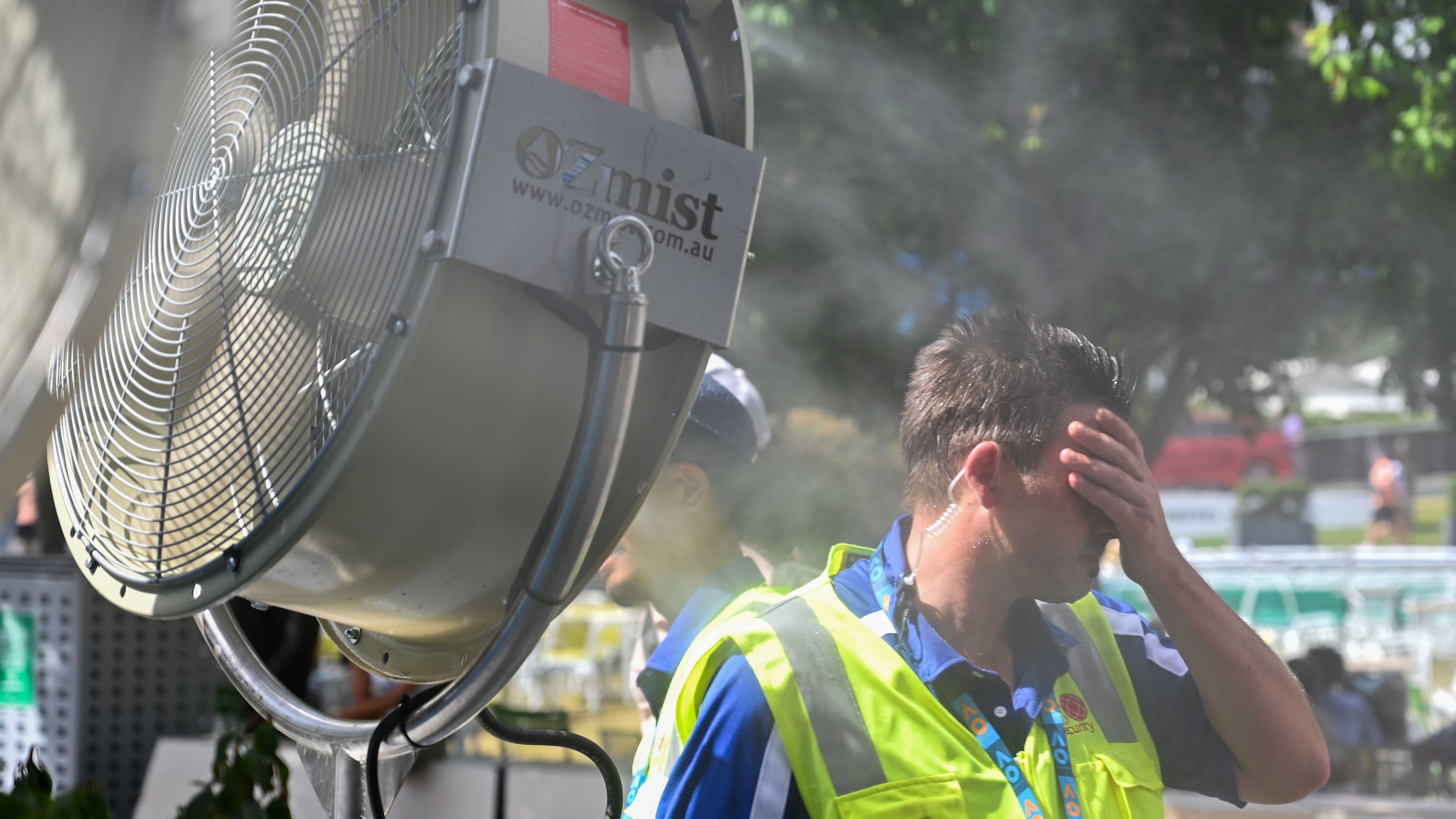 A man cools down in front of a mist fan at the Australian Open on Friday, January 25.