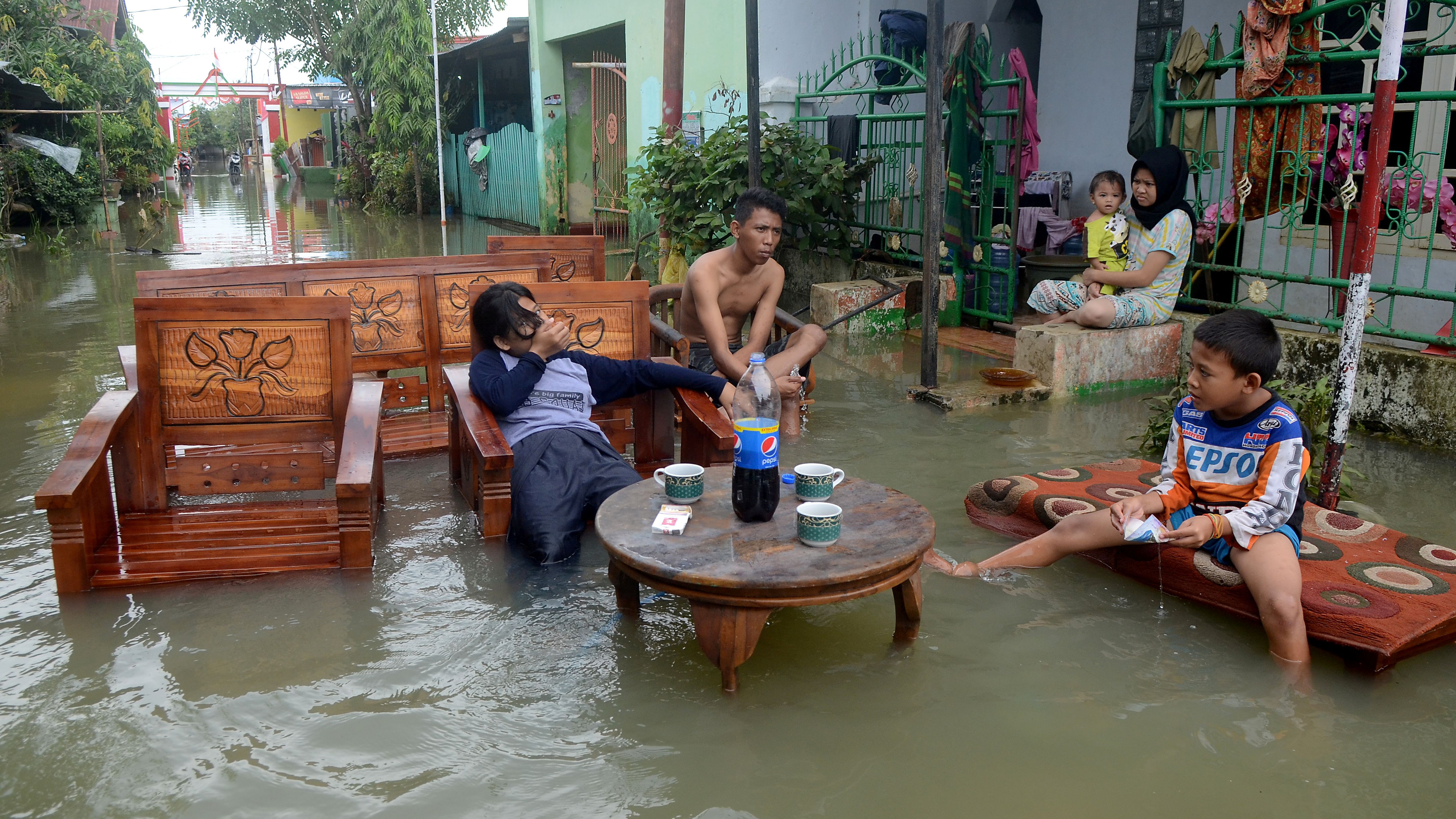 Residents sit on furniture following floods in Makassar, Indonesia, on Friday, January 25.
