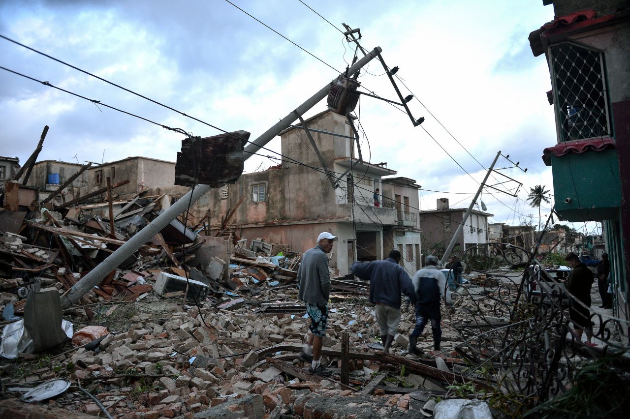 Residents of Havana, Cuba, walk amid debris Monday, January 28, after a rare tornado hit the city.