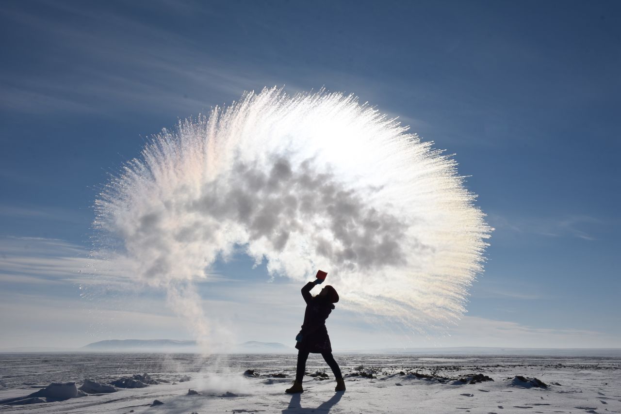 A woman tosses hot water into the freezing cold air in Kars, Turkey, on Sunday, January 20.