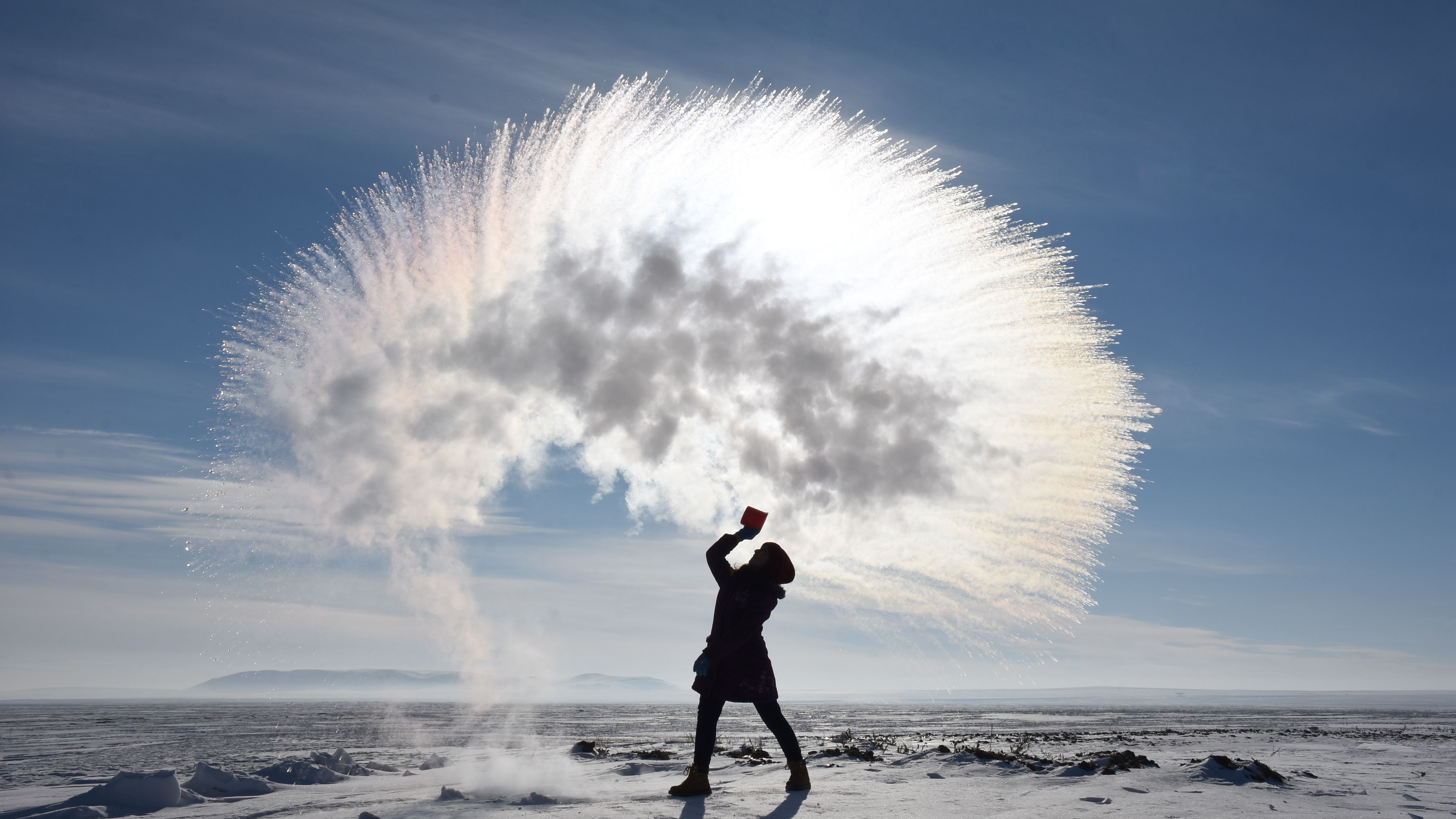 A woman tosses hot water into the freezing cold air in Kars, Turkey, on Sunday, January 20.