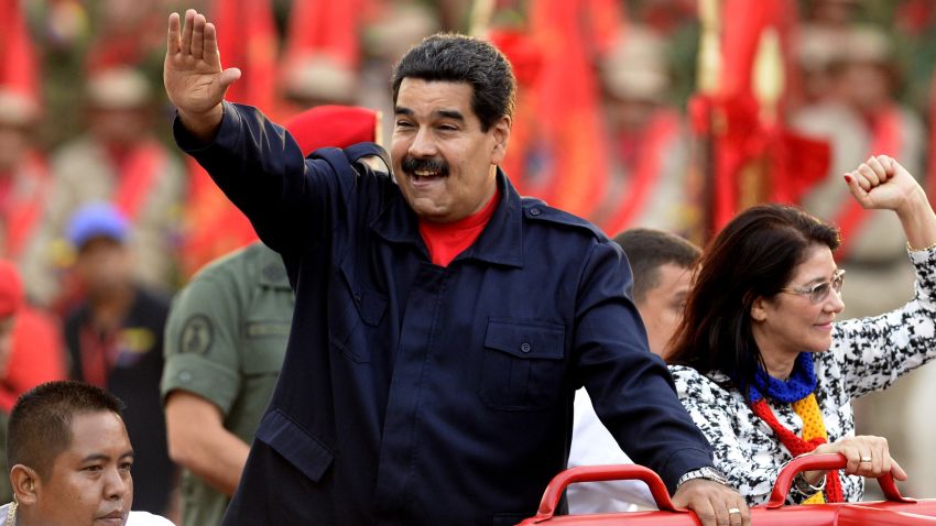 Venezuelan President Nicolas Maduro (L) waves as he arrives with his wife Cilia Flores during the celebrations for the fifth anniversary of the Bolivarian Militia in Caracas on April 13, 2015. AFP PHOTO/FEDERICO PARRA (Photo credit should read FEDERICO PARRA/AFP/Getty Images)
