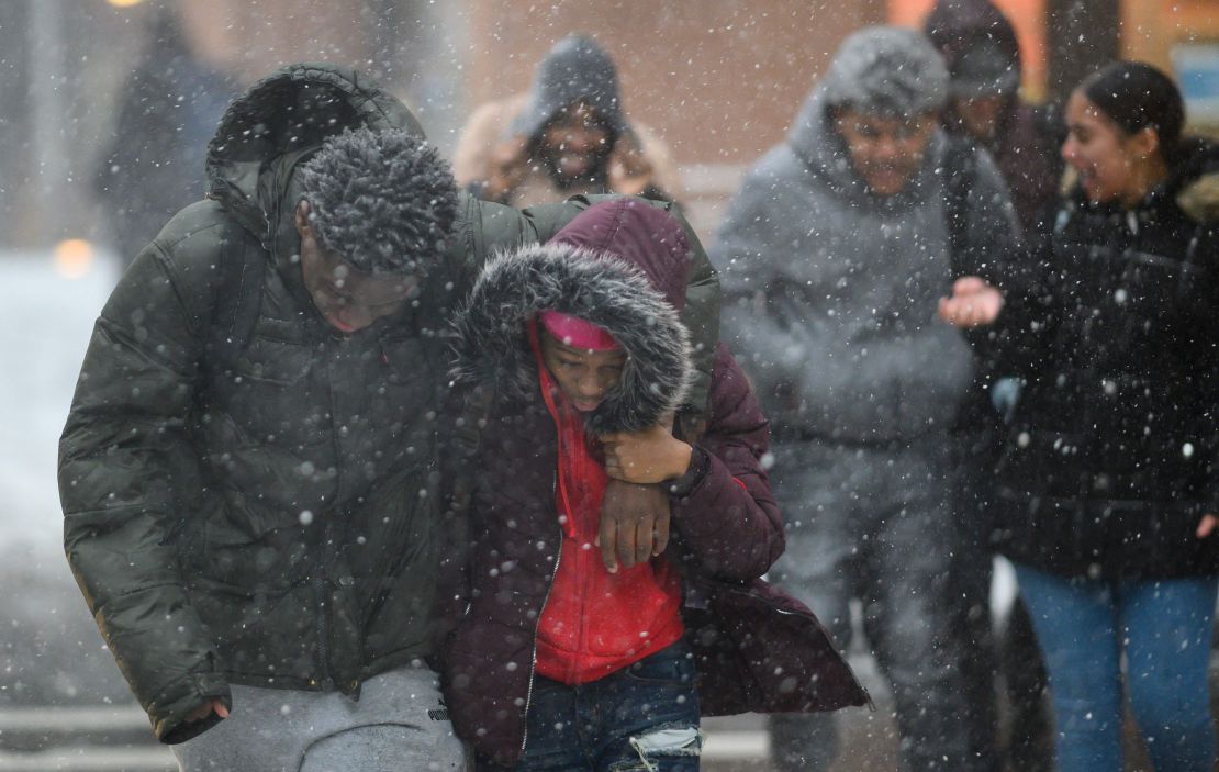 Pedestrians duck the wind as they  walk through heavy snow in Manhattan on Wednesday.