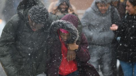 Pedestrians duck the wind as they  walk through heavy snow in Manhattan on Wednesday.