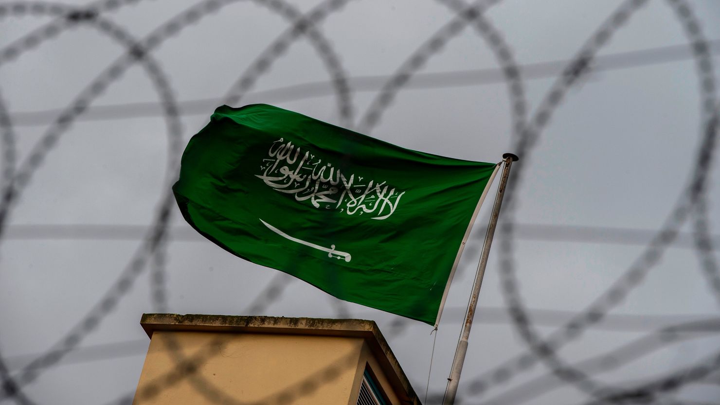 A Saudi Arabia flag flies behind barbed wires at the Saudi Arabian consulate in Istanbul.