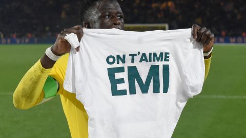Nantes defender Abdoulaye Toure holds a shirt reading "EMI we love you," during a tribute ceremony on January 30.