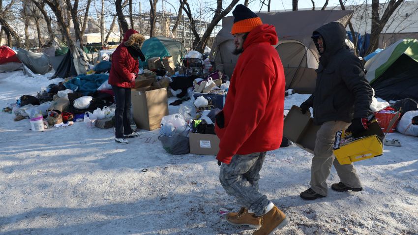 Felipe, center, and George Arroyo, right, look for carton boxes to burn inside a garbage can to keep an improvised fire going at a makeshift camp on Roosevelt Road near the Dan Ryan Expressway on Jan 30, 2019. (Abel Uribe/Chicago Tribune/TNS via Getty Images)