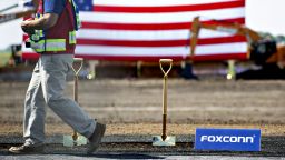 A worker walks past shovels in a patch of dirt ahead of the groundbreaking ceremony for the Foxconn Technology Group facility in Mount Pleasant, Wisconsin, U.S., on Thursday, June 28, 2018. After repeatedly bashing the leadership of Harley-Davidson Inc. this week, President Donald Trump is set to be 30 miles away from its corporate headquarters during the groundbreaking for the Foxconn Technology Group electronic screen manufacturing campus. Photographer: Daniel Acker/Bloomberg via Getty Images