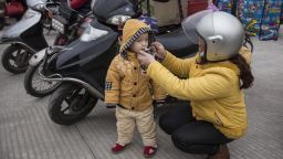 ZHAOQING, CHINA - JANUARY 25: (CHINA OUT) A mother feeds their child porridge at a gas station after riding their motorcycle on January 25, 2019 in Zhaoqing, Guangdong Province, China. The Motorcycle Return League refers to the migrant workers who ride motorcycles back home together. Many migrant workers in Guangdong choose this way to go home for the Spring Festival and the Chinese media call these people the "Motorcycle Army", which started at the Spring Festival of 2000. In the Spring Festival of 2014, the flow of motorcycles returning home increased dramatically with more than 600,000 migrant workers chosing to ride motorcycles back to their homes in Guangxi, Guizhou and other provinces and regions. With the development of high-speed railways and the popularization of private cars, the number of motorcycle riders has dropped sharply for the Spring Festival of 2019. (Photo by Wang He/Getty Images)