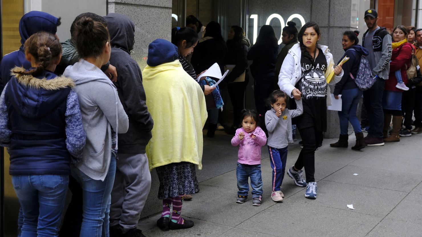 Hundreds of people overflow onto the sidewalk in a line snaking around the block outside a U.S. immigration office with numerous courtrooms Thursday, Jan. 31, 2019, in San Francisco. (AP Photo/Eric Risberg)