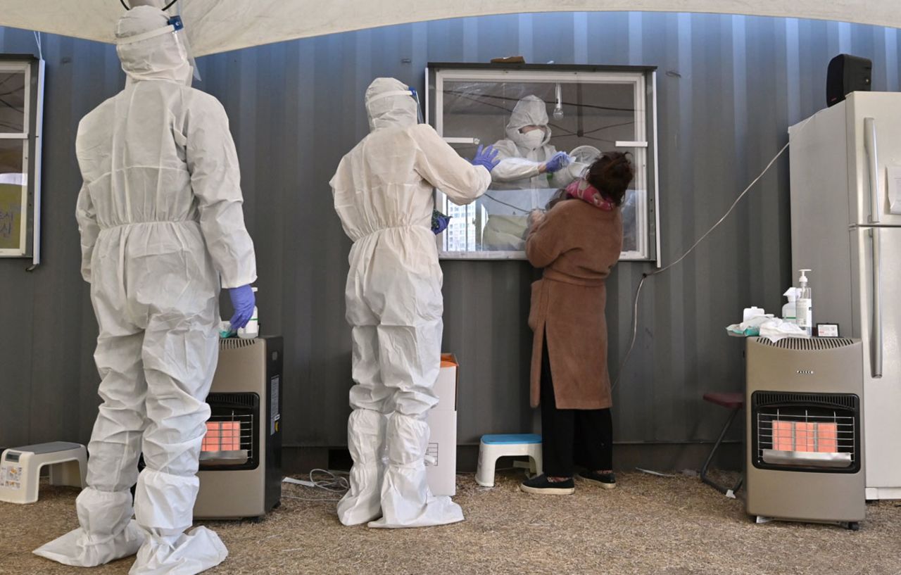 A medical staff member takes a swab for a Covid-19 test at a temporary testing station in Seoul on December 16.