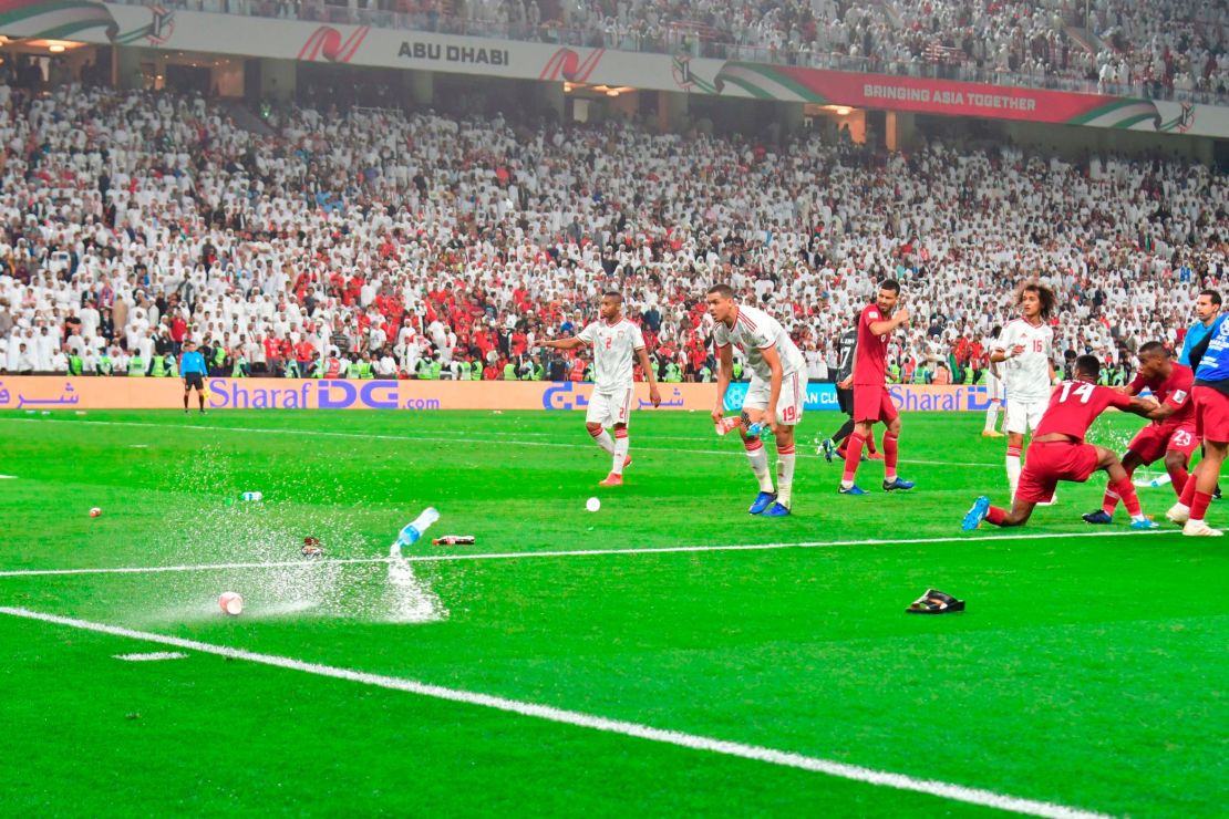 Fans throw bottles and sandals onto the pitch during the Qatar-UAE semifinal.