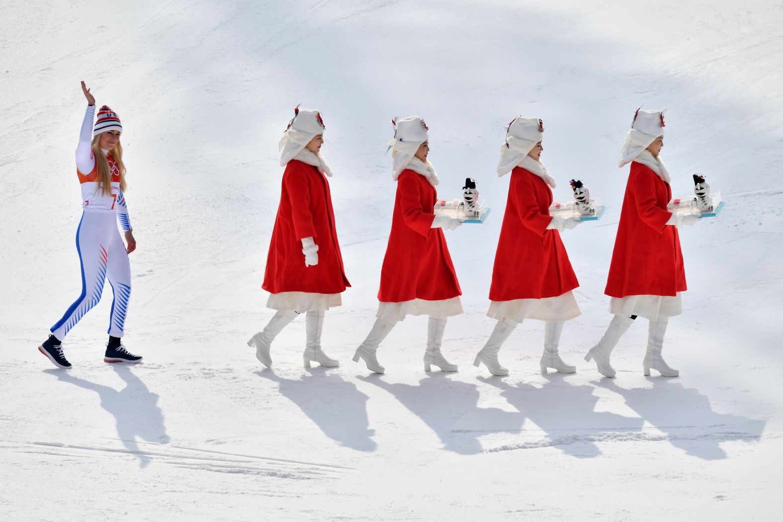 Vonn follows hostesses at the medal ceremony for the Olympic downhill event in February 2018. She won the bronze in what she said would likely be her final Olympic downhill race.