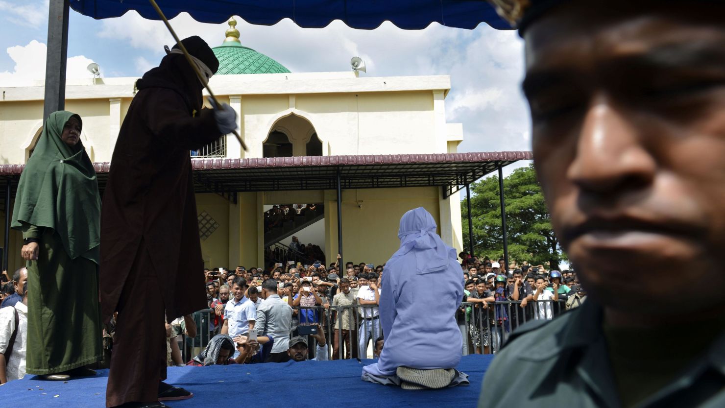An Indonesian teen is caned in public in Banda Aceh as punishment for being caught cuddling with her boyfriend.