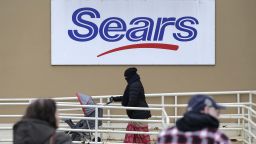 A person walks near a sign for a Sears store in Hackensack, N.J., Tuesday, Jan. 8, 2019. Sears is getting another reprieve from liquidation after its chairman and largest shareholder revised his bid to save the iconic brand, according to a hearing  Tuesday at the bankruptcy court in White Plains, N.Y. (AP Photo/Seth Wenig)