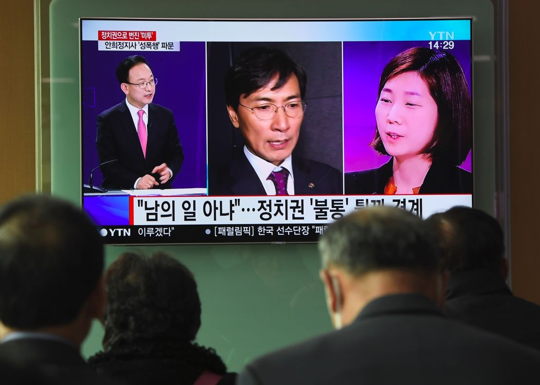 People watch a television news report showing a picture of Kim Ji-eun (right on television), a secretary of Ahn Hee-jung, at a railway station in Seoul on March 6, 2018.