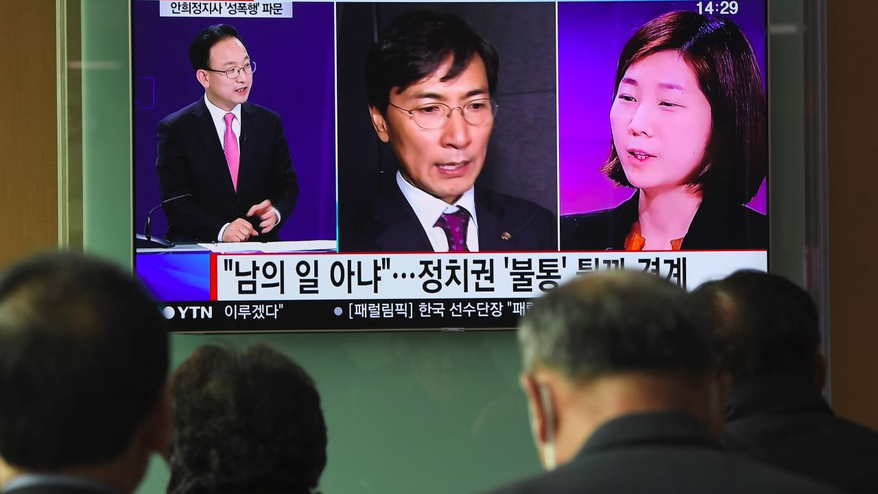 People watch a television news report showing a picture of Kim Ji-eun (right on television), a secretary of Ahn Hee-jung, at a railway station in Seoul on March 6, 2018.