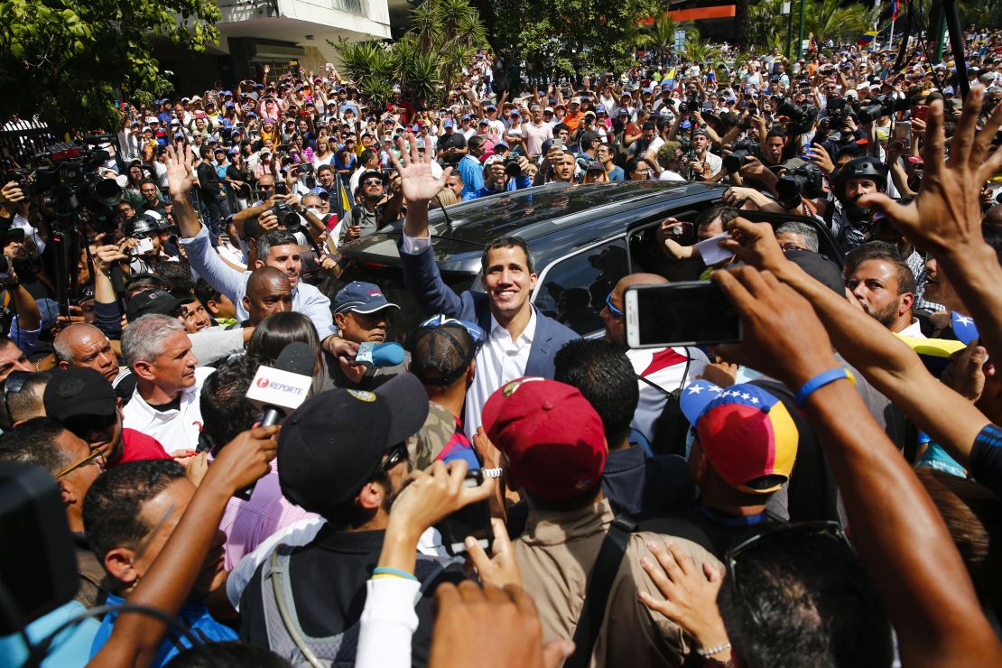 Juan Guaido waves to supporters as he leaves a Saturday rally in Caracas.