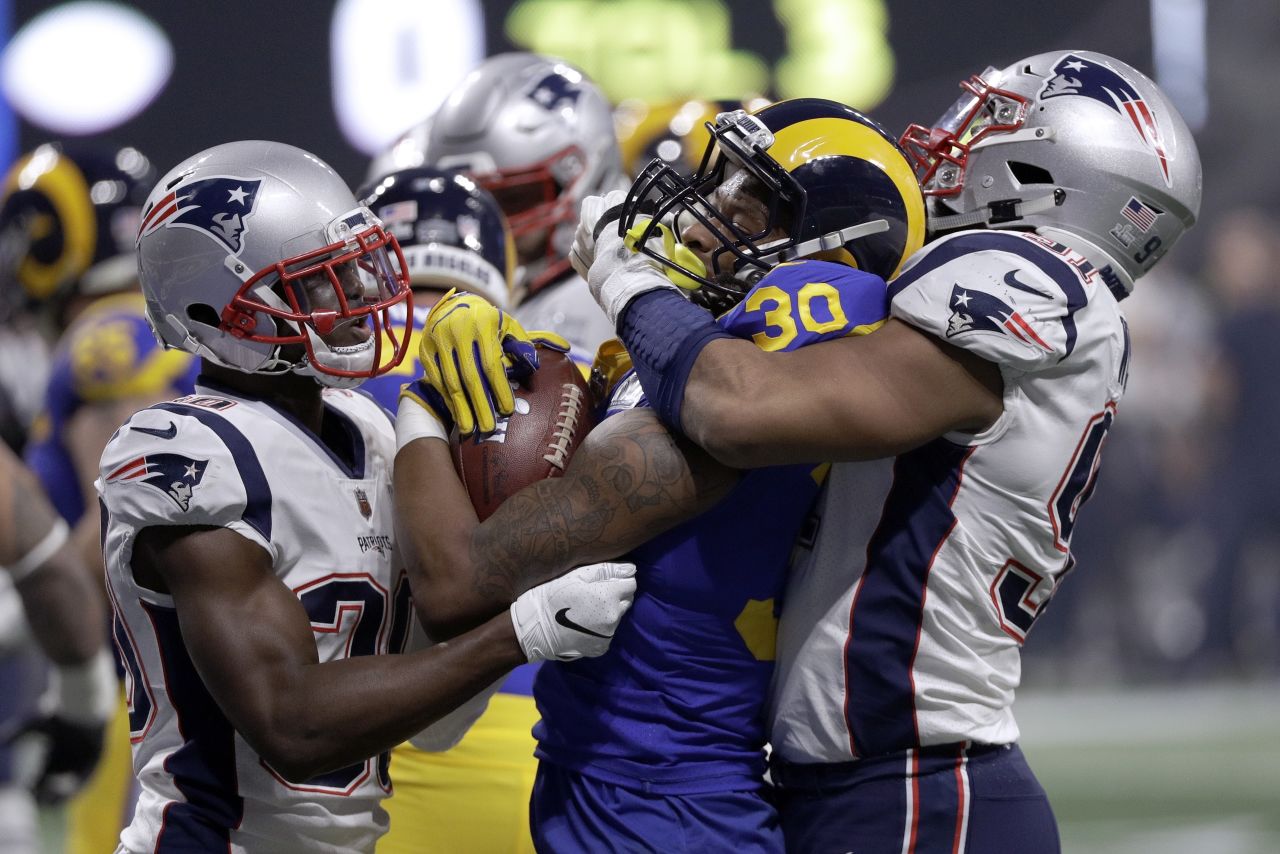 Rams running back Todd Gurley II is tackled by McCourty, left, and Deatrich Wise Jr. in the second half.