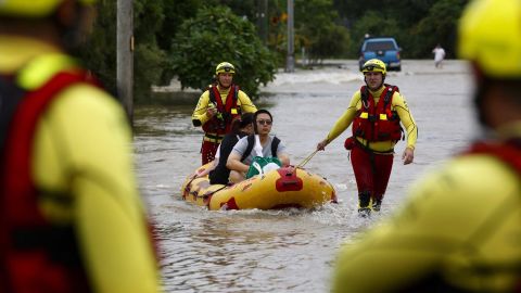 Emergency services use an inflatable boat to pull residents through floodwaters at Hermit Park in Townsville.