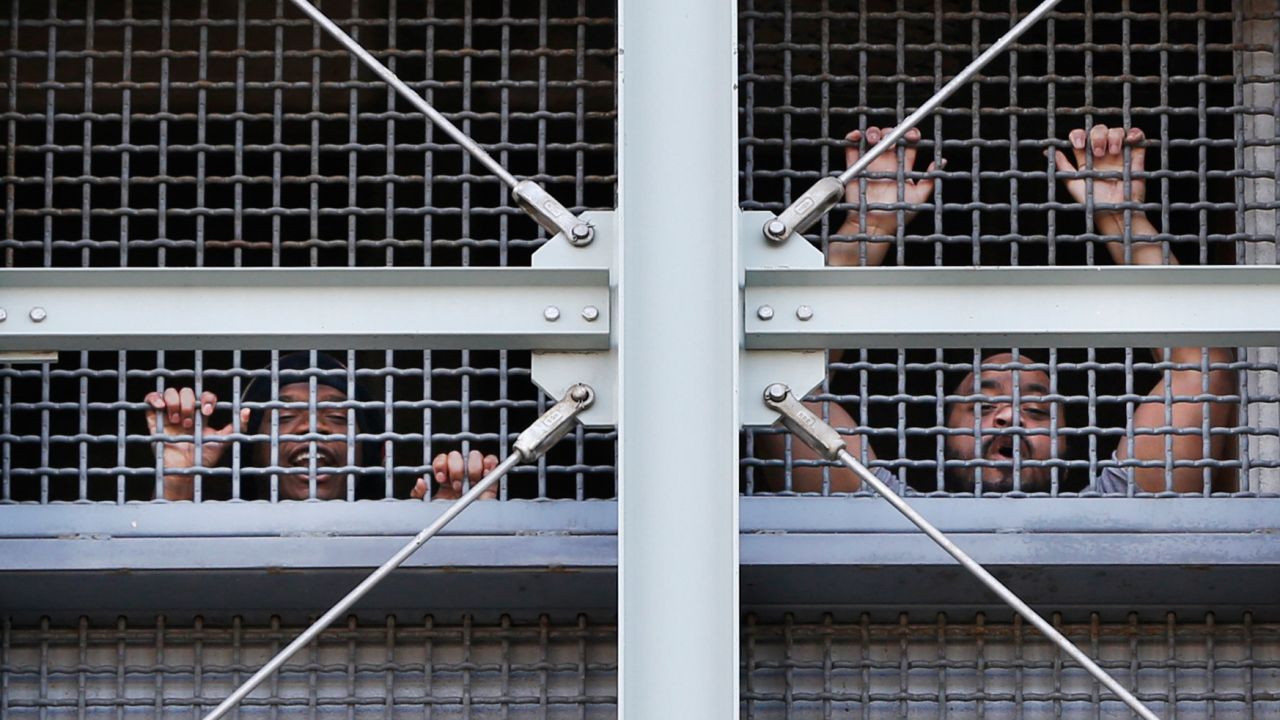 Prisoners call out to protesters and family members gathered outside the Metropolitan Detention Center.