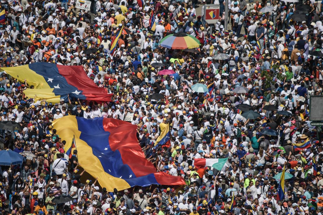 Guaido supporters hold huge Venezuelan flags during a protest against Maduro on Saturday. 
