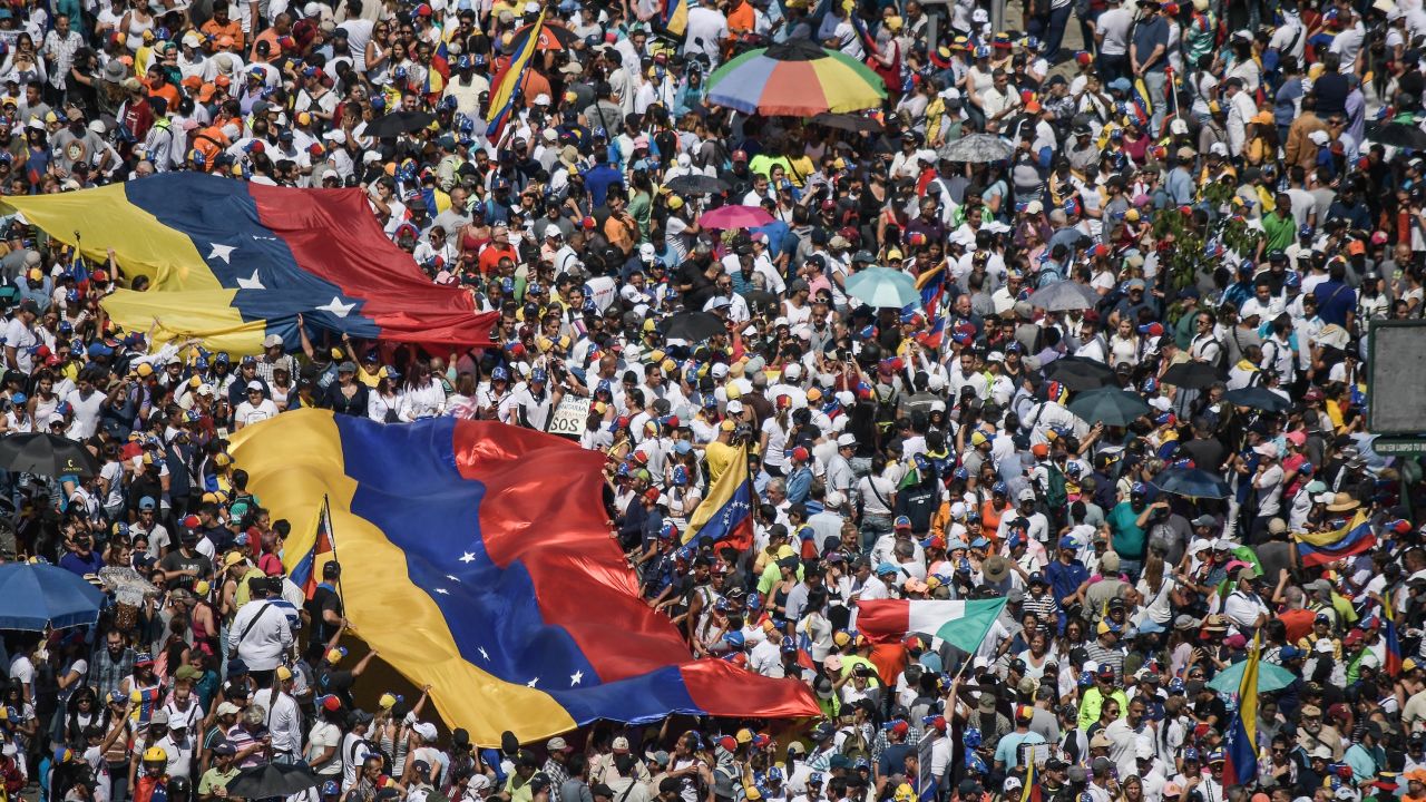 Guaido supporters hold huge Venezuelan flags during a protest against Maduro on Saturday.