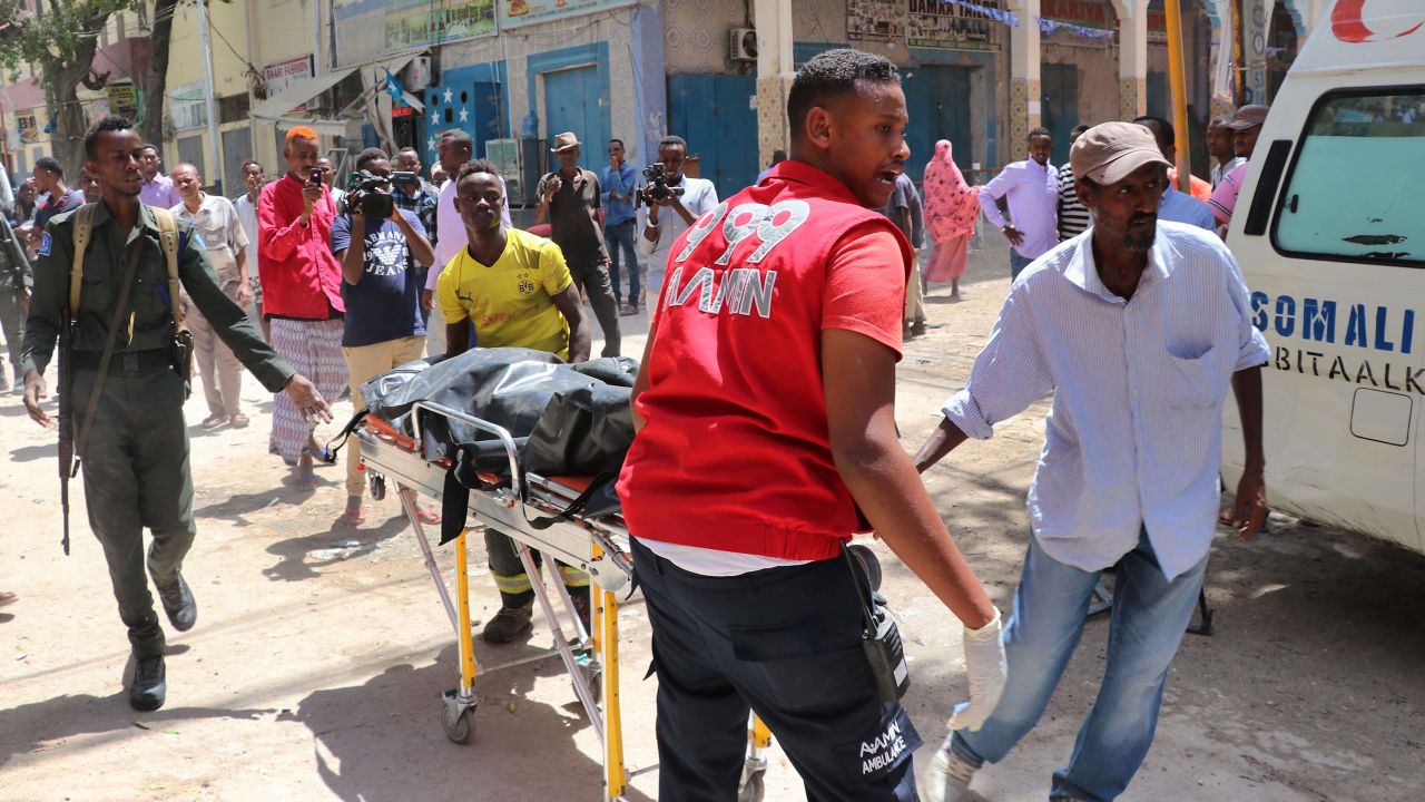 Emergency rescue staff carry the body of a victim on a gurney at the scene of a car-bomb attack on February 4, 2019 in Somalia capital Mogadishu's Hamarwayne District. (Photo by ABDIRAZAK HUSSEIN FARAH / AFP)        