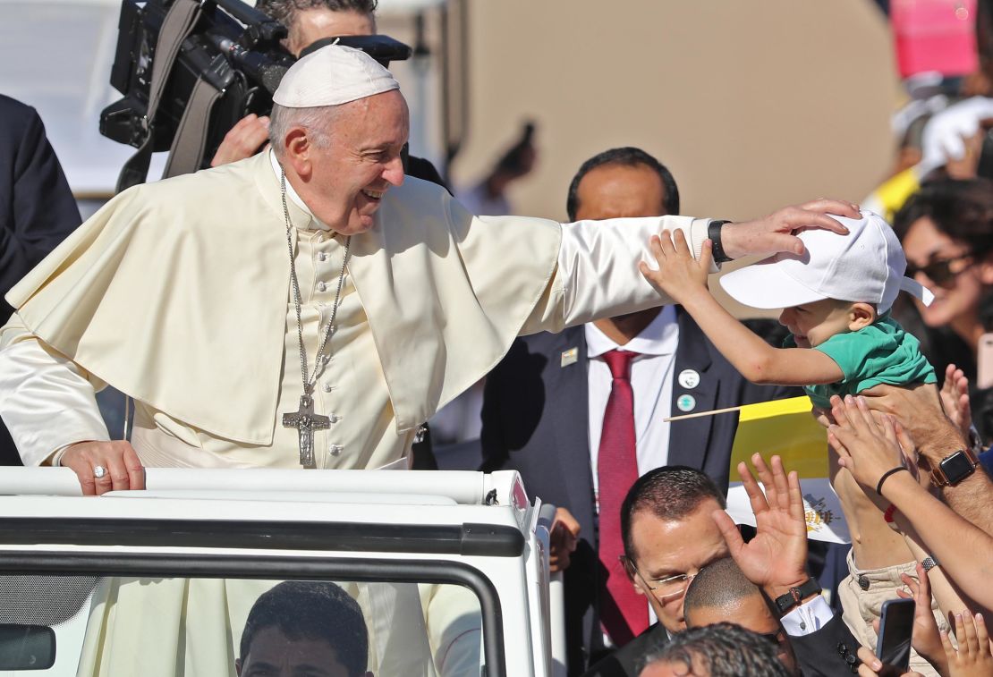 Francis blesses a child as he arrives at Tuesday's Mass. 