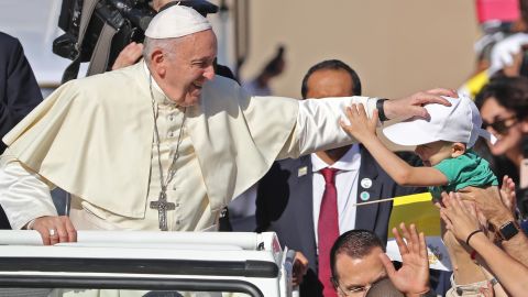 Francis blesses a child as he arrives at Tuesday's Mass.