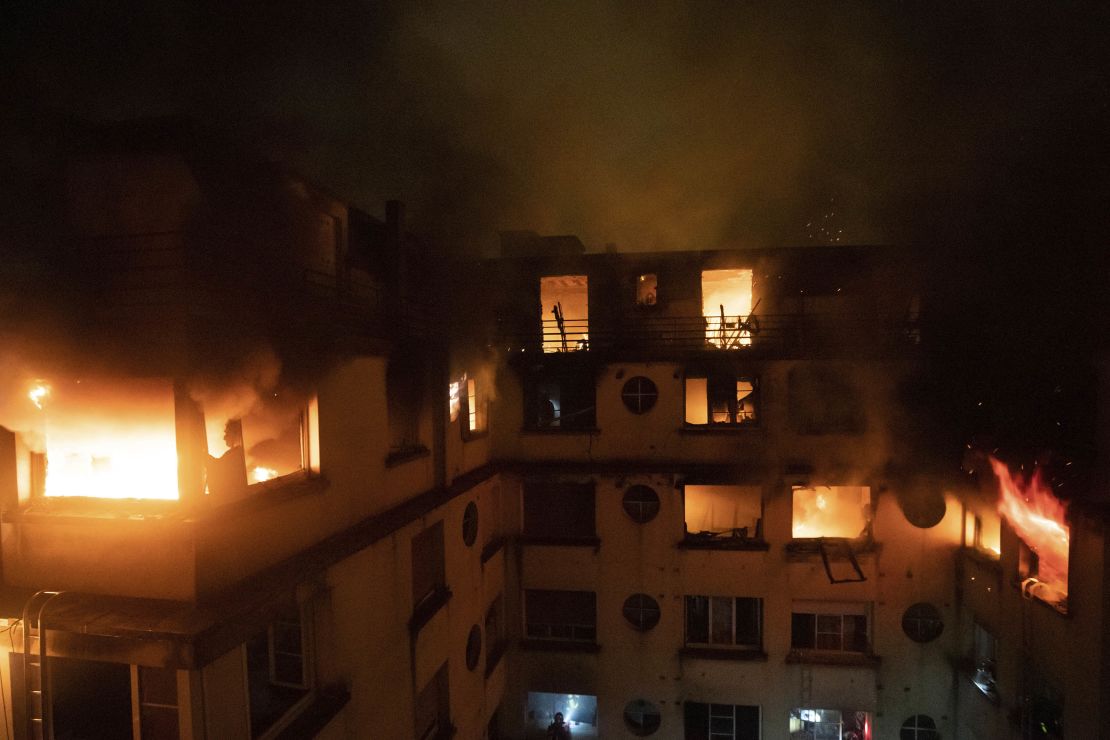 A fire rages through the top floors of an apartment building in Paris, France