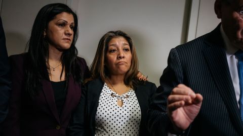 Sandra Diaz, left, and Victorina Morales,  stand behind Sen. Bob Menendez as he gives a press conference about their speaking out about being undocumented workers who formerly worked at Trump properties.