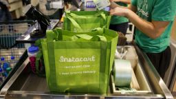 InstaCart employees fulfill orders for delivery at the new Whole Foods Market Inc. store in downtown Los Angeles, California, U.S., on Monday, Nov. 9, 2015. 