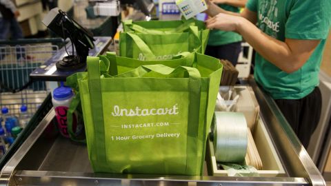 InstaCart employees fulfill orders for delivery at the new Whole Foods Market store in downtown Los Angeles
