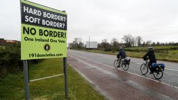 Cyclists pass a sign calling for no border to be imposed between Ireland and Northern Ireland outside Newry, Northern Ireland, on November 14, 2018 near the Irish border. - British Prime Minister Theresa May defended her anguished divorce deal with the European Union before rowdy lawmakers on Wednesday before  trying to win the backing of her splintered cabinet with the so-called "Irish backstop" arrangement to guard against the imposition of a hard border between Ireland and Northern Ireland one of the contentious issues, according to reports. (Photo by Paul FAITH / AFP)        (Photo credit should read PAUL FAITH/AFP/Getty Images)