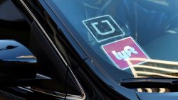 FILE - In this Jan. 12, 2016 file photo, a ride share car displays Lyft and Uber stickers on its front windshield in downtown Los Angeles, Calif.  Ride-hailing giants Uber and Lyft have launched subscription plans promising savings for trips to the gym, to work or around town. The ride-hailing companies stand to gain by increasing customer loyalty in a competitive market and securing more predictable revenue at a time when both companies are heading to an initial public offering.   (AP Photo/Richard Vogel, File)