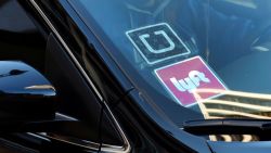 FILE - In this Jan. 12, 2016 file photo, a ride share car displays Lyft and Uber stickers on its front windshield in downtown Los Angeles, Calif. Ride-hailing giants Uber and Lyft have launched subscription plans promising savings for trips to the gym, to work or around town. The ride-hailing companies stand to gain by increasing customer loyalty in a competitive market and securing more predictable revenue at a time when both companies are heading to an initial public offering. (AP Photo/Richard Vogel, File)