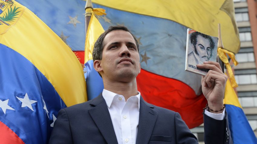 TOPSHOT - Venezuela's National Assembly head Juan Guaido declares himself the country's "acting president" during a mass opposition rally against leader Nicolas Maduro, on the anniversary of a 1958 uprising that overthrew military dictatorship in Caracas on January 23, 2019. - Moments earlier, the loyalist-dominated Supreme Court ordered a criminal investigation of the opposition-controlled legislature. "I swear to formally assume the national executive powers as acting president of Venezuela to end the usurpation, (install) a transitional government and hold free elections," said Guaido as thousands of supporters cheered. (Photo by Federico PARRA / AFP)        (Photo credit should read FEDERICO PARRA/AFP/Getty Images)